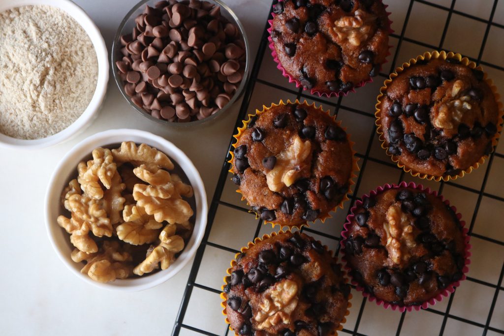 Millet Muffins - A tray of muffins kept with choco chips, walnut and pancake mix on the side