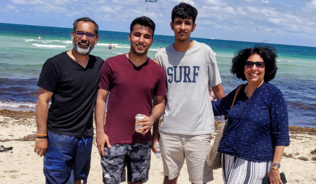 Celebrating Father's Day With Superdad Sandeep Sareen. A family standing together with two sons, mom and dad on a beach.