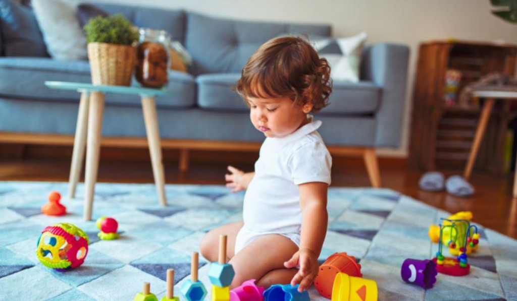 25 Children Activities To Make Quarantine Fun. A baby girl playing with her toys.